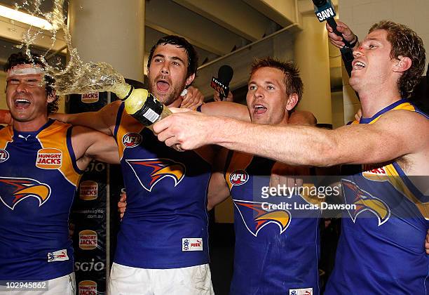 Josh Kennedy and Mark Lecras and Scott Selwood of the Eagles sing the team song after the round 16 AFL match between the Essendon Bombers and the...