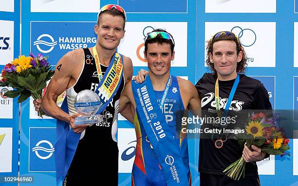 Gold medal winner Javier Gomez of Spain celebrates on the podium with second Jan Frodeno of Germany and third Tim Don of Great Britain during the...
