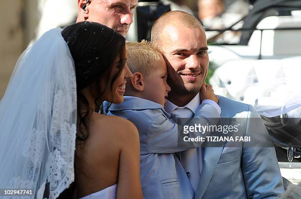 Inter-Milan's Dutch football player Wesley Sneijder holds his son Jessey as he stands with Dutch model Yolanthe Cabau outside the Church of San...