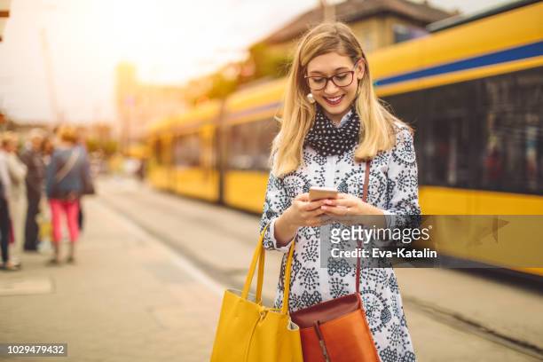 年輕的女人正在檢查她的留言 - tram 個照片及圖片檔