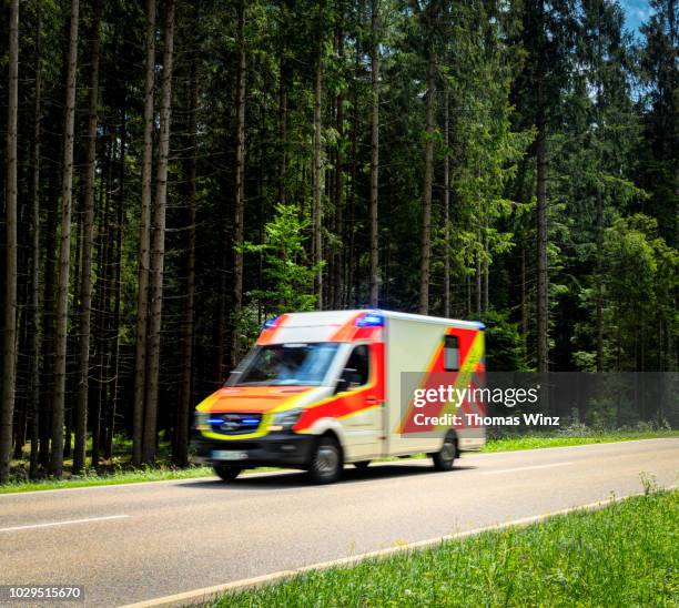 ambulance driving through a forest - vehículo de emergencia fotografías e imágenes de stock