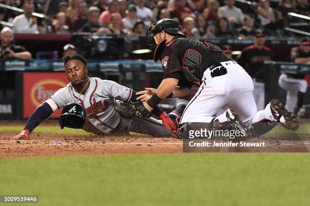 Jeff Mathis of the Arizona Diamondbacks tags Ozzie Albies of the Atlanta Braves out at home in the second inning of the MLB game at Chase Field on...