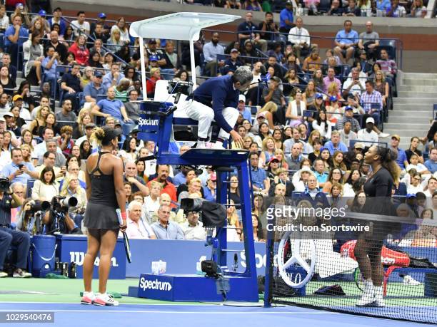 Chair umpire Carlos Ramos explains game penalty t0 Serena Williams and Naomi Osaka after Williams was penalized a game for verbal abuse in the final...