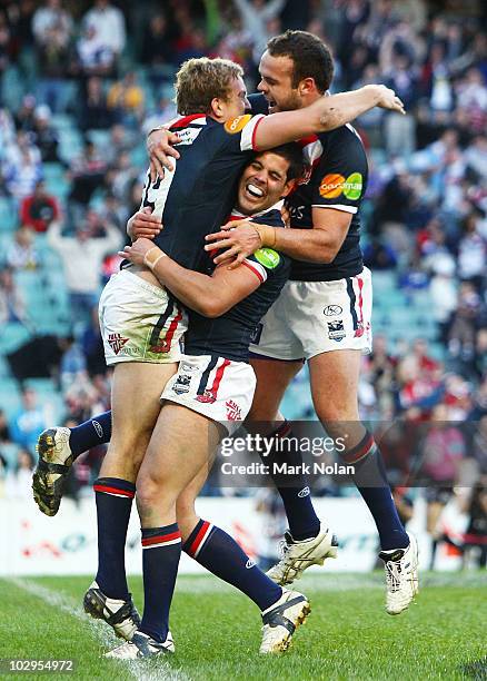 Mitchell Aubusson, Nick Kouparitsas and Nate Myles of the Roosters celebrate the match winning try by Mitchell Aubusson during the round 19 NRL match...