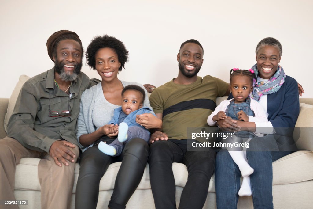 Retrato de familia de tres generaciones en casa sonriendo