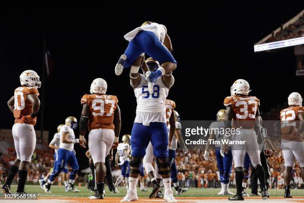 Willie Wright of the Tulsa Golden Hurricane lifts Shamari Brooks after a rushing touchdown in the second half against the Texas Longhorns at Darrell...