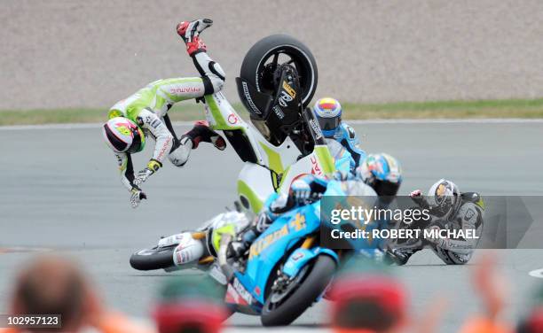 Spain's Ducati rider Aleix Espargaro and Frace's Honda driver Randy De Puniet crash during the Moto Grand Prix race of Germany at Sachsenring Circuit...