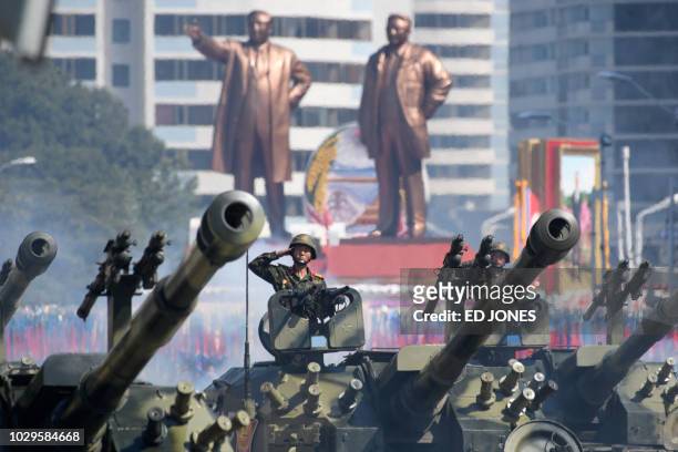 Korean People's Army soldiers salute as they ride tanks during a military parade and mass rally on Kim Il Sung square in Pyongyang on September 9,...