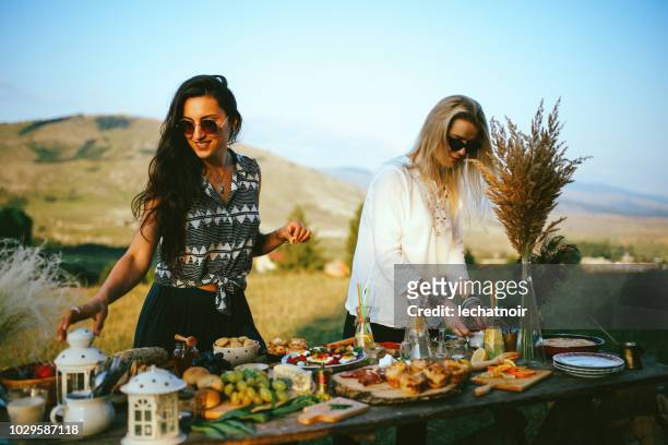 junge frauen, die zubereitung von speisen für picknick im grünen - man eating pie stock-fotos und bilder