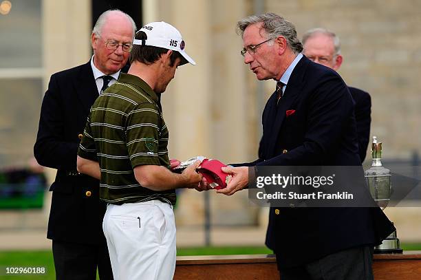 Louis Oosthuizen of South Africa is presented with a belt to commemorate the 150th year of the championship by Brian Morrison, Captain of Prestwick...