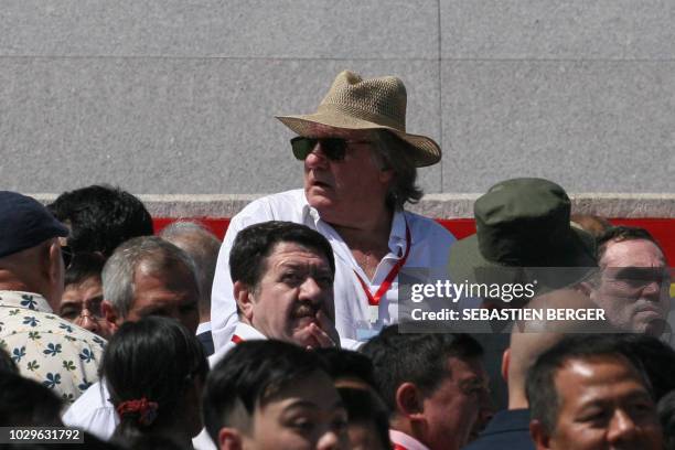 French actor Gerard Depardieu looks on as he attends a military parade with an entourage including French writer Yann Moix and mass rally on Kim Il...