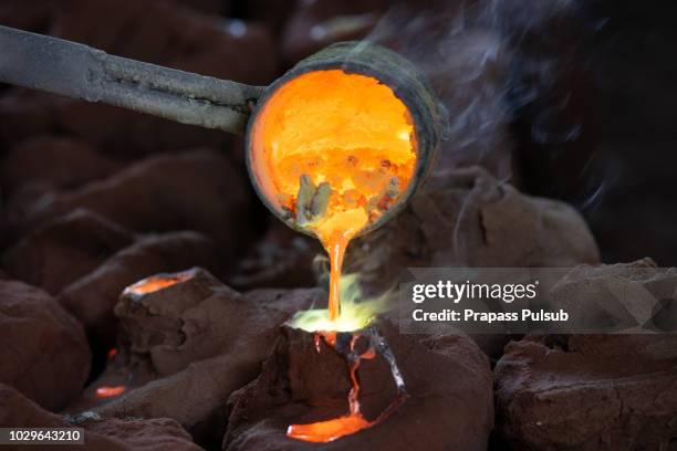 foundry - molten metal poured from ladle - fließend stock-fotos und bilder