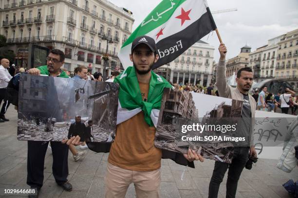 Syrian refugee seen with photos of the war during the protest in support of the Syrian revolution and against Bashar al-Àssad demanding the release...