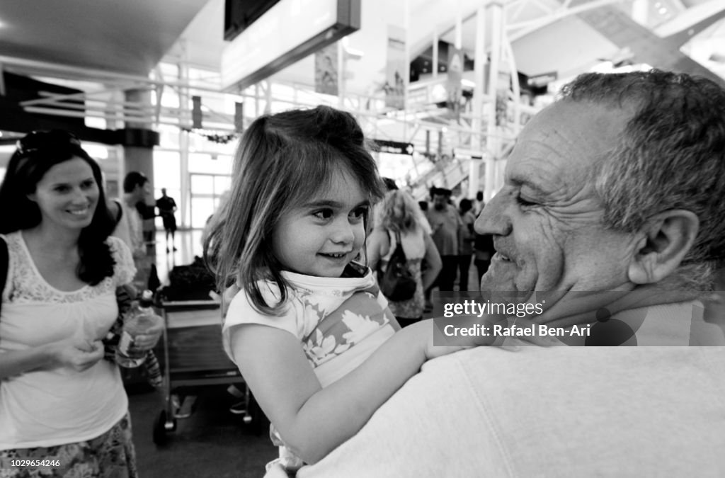 Happy Active Senior Grandfather Holding his Granddaughter