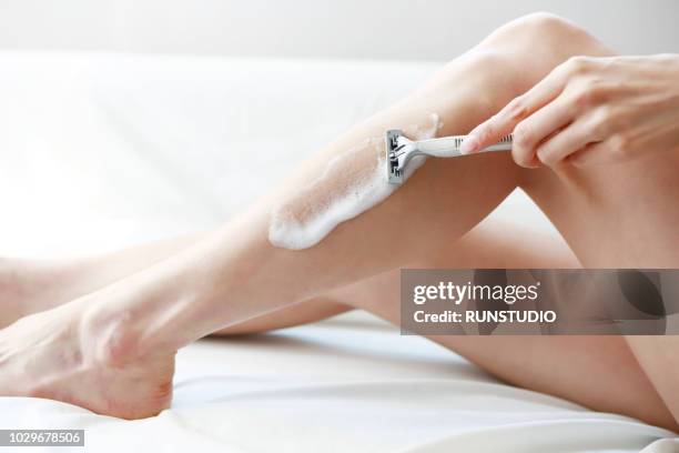 close-up of woman shaving leg - adult woman legs close up stock-fotos und bilder