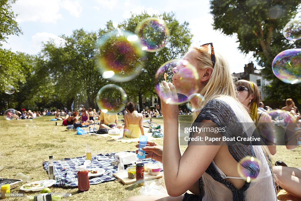 Friends blowing bubbles in the park