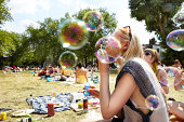 Friends blowing bubbles in the park