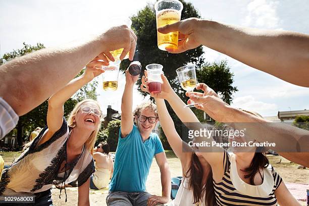 friends raising a toast in the park  - young men drinking beer stock pictures, royalty-free photos & images
