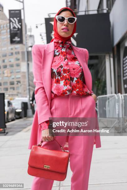 Melanie Zedan is seen wearing a pink Zara suit with a floral Zara top and a red hijab from Haute Hijab on the street during New York Fashion Week on...