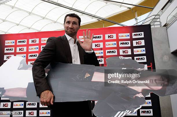 Boxer Wladimir Klitschko of Ukraine carries a poster of his opponent Alexander Povetkin during a press conference at the Commerzbank Arena on July...