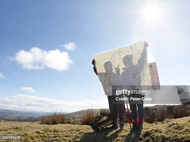 two hikers looking at map - guidance - fotografias e filmes do acervo