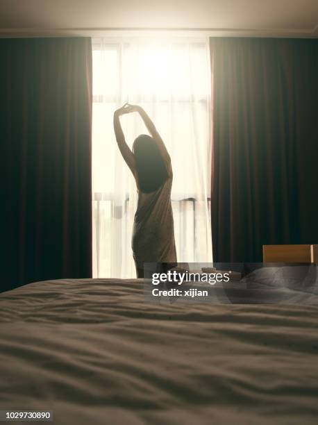 stretching in front of bedroom window - morning stretch stock pictures, royalty-free photos & images