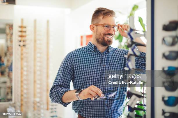 光学店でサングラスを買う若者 - 2018 glasses ストックフォトと画像
