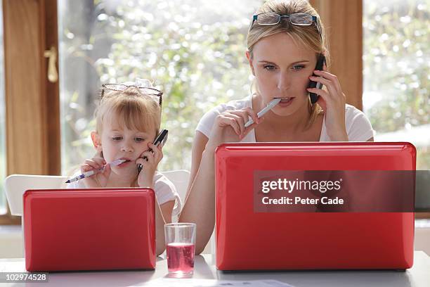 daughter copy mother working on laptop - caricatura fotografías e imágenes de stock