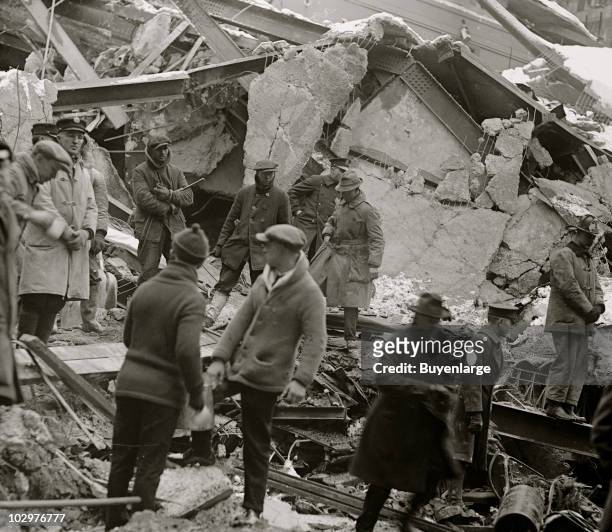 Policeman, rescue workers, and onlookers stand amid the wreckage of the Knickerbocker Theatre, Washington DC, January 29, 1922. The structure's roof...