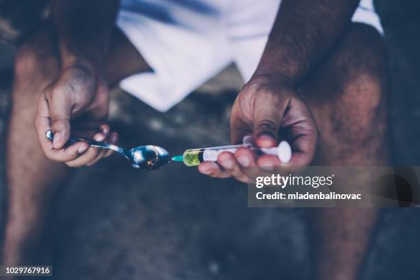 preparing his dose - heroin addict arm stock pictures, royalty-free photos & images