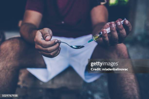 preparing his dose - heroin addict arm stock pictures, royalty-free photos & images