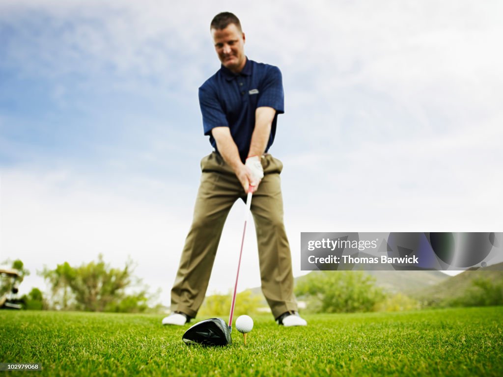 Male golfer preparing to hit tee shot
