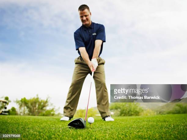 male golfer preparing to hit tee shot - male golfer stock pictures, royalty-free photos & images