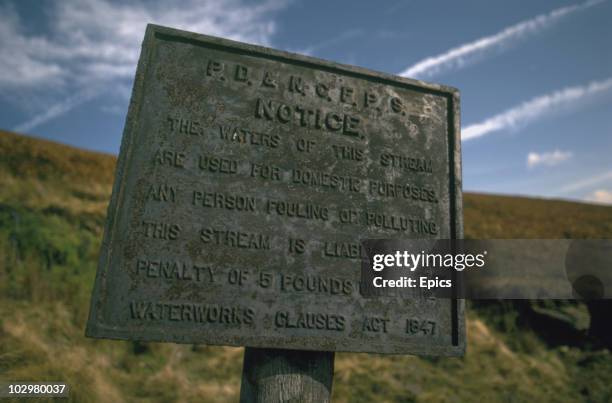 Sign warning against polluting the local stream in the countryside of Kinder walk in the Peak District, November 1973. The sign reads ' The waters of...