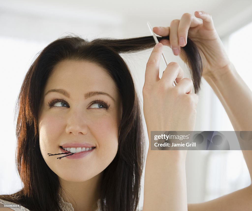 Young woman combing and styling her hair