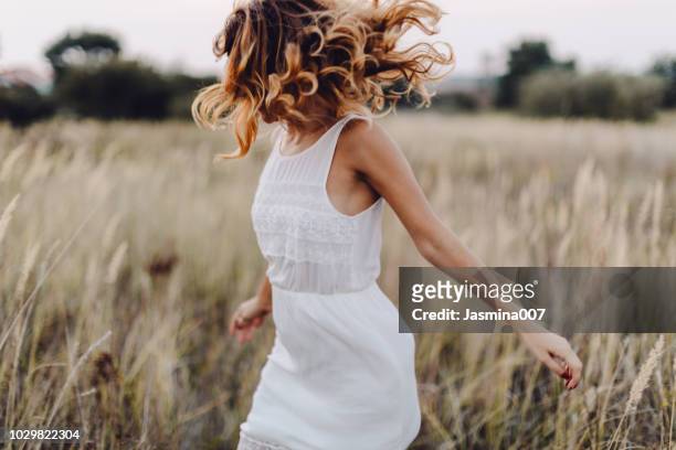 jonge vrouw buiten genieten van de zonsondergang - human hair stockfoto's en -beelden