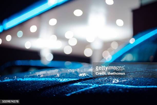 close-up of a wet car at a petrol station during night, germany - selective focus stock-fotos und bilder