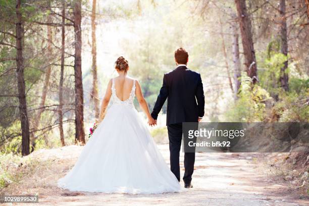 wedding couple walking on road. - just married sign stock pictures, royalty-free photos & images