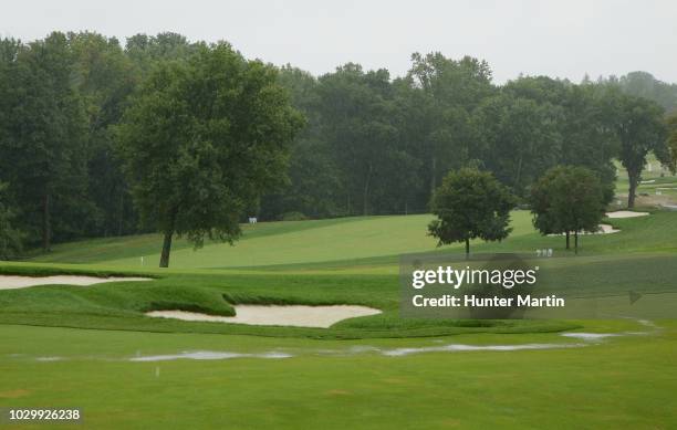 Stream of rain water runs down the 18th fairway during a weather delay prior to the final round of the BMW Championship at Aronimink Golf Club on...