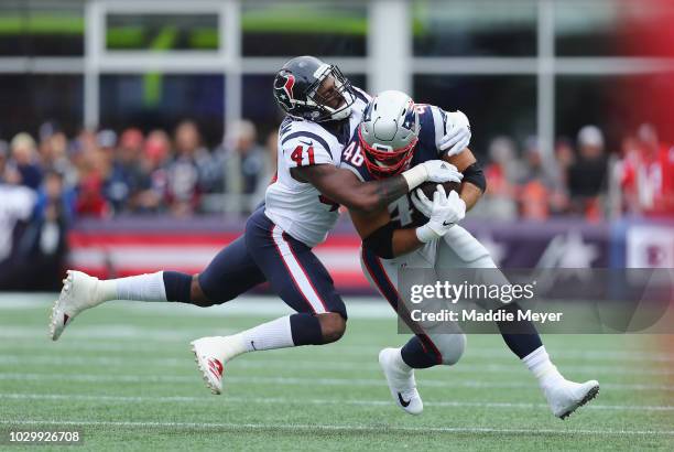 Zach Cunningham of the Houston Texans tackles James Develin of the New England Patriots during the first half at Gillette Stadium on September 9,...