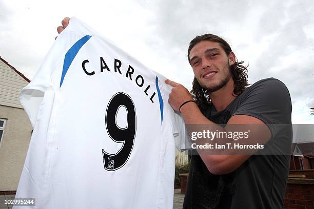 Andy Carroll holds up the number 9 shirt after Newcastle manager Chris Hughton handed the legendary No 9 shirt to Carroll for the coming season at...