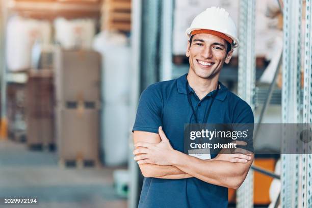 smiling young man with work helmet in a warehouse - loading dock stock pictures, royalty-free photos & images