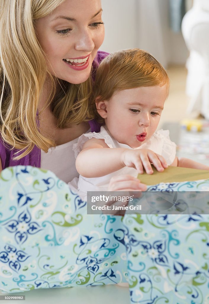 Mother and baby girl opening present