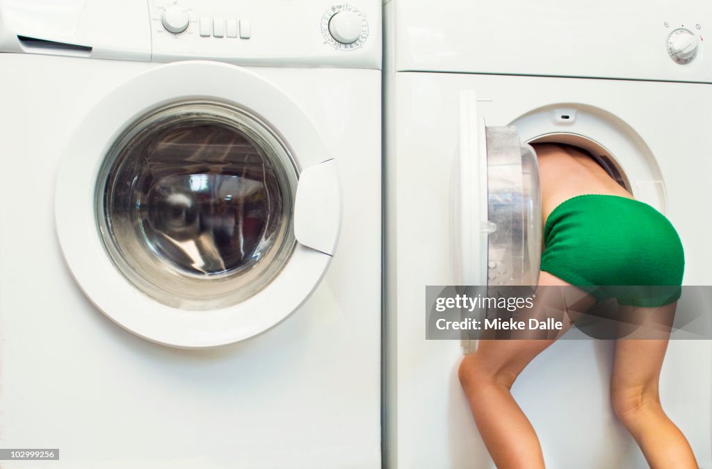 Child leaning in tumble dryer or washing machine