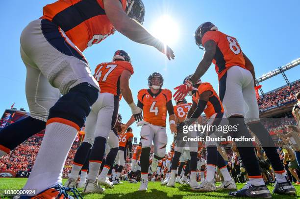 Quarterback Case Keenum of the Denver Broncos runs onto the field during player introductions before a game against the Seattle Seahawks at Broncos...