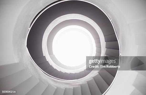 view from bottom of spiral staircase. - infinite stairs stock pictures, royalty-free photos & images