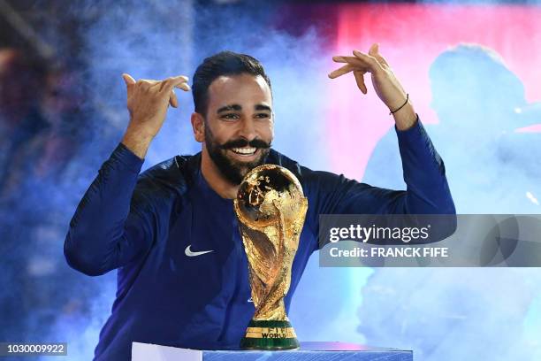 France's defender Adil Rami poses with the 2018 World Cup trophy before the lap of honour at the end of the UEFA Nations League football match...