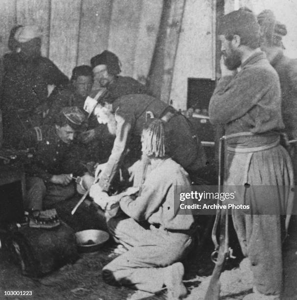 Army doctors performing an amputation in a make-shift hospital during the American Civil War, USA, circa 1863.