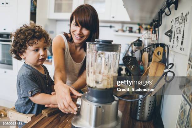 mom with her toddler boy prepares healthy food - blender stock pictures, royalty-free photos & images