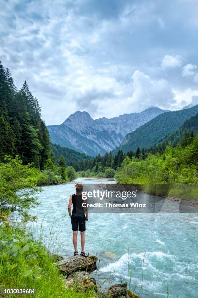 woman looking at view mountain range and creek - karwendel mountains stock pictures, royalty-free photos & images